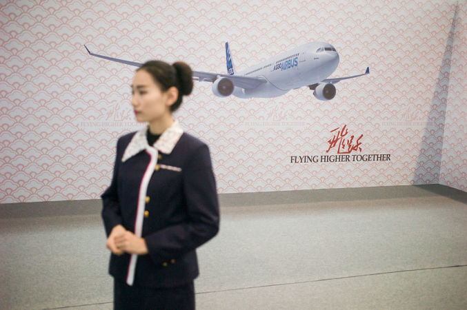 天津で、エアバス社の新機種を中国で展開するセレモニーが3月行われた。客人を迎えるコンパニオン(FRED DUFOUR/AFP/Getty Images)