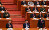 北京の人民大会堂で5日、全国人民代表大会の開幕式が開かれた。習近平国家主席（中央）と、スピーチを終え着席する李克強首相（向かって右）。（Lintao Zhang/Getty Images）