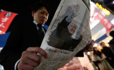 フランス在住の中国人ベテランジャーナリスト・呉葆璋氏は、日本の報道機関に向けて中国報道の観察の視点をアドバイス。新聞を広げる日本人男性（Yuya Shino/Getty Images）