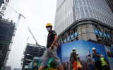 7月、北京の建設現場近くを歩く作業員（WANG ZHAO/AFP/Getty Images）
