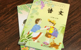 劉さんが見せてくれた中国の小学校教科書。カバーには母親が息子に赤いスカーフを着ける絵がある。（文亮/大紀元）