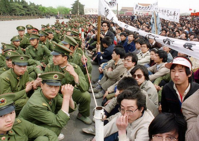 1989年4月22日、天安門広場で、数万人の民主化を求める学生ら若者と、警察隊が対峙する（CATHERINE HENRIETTE/AFP/Getty Images）