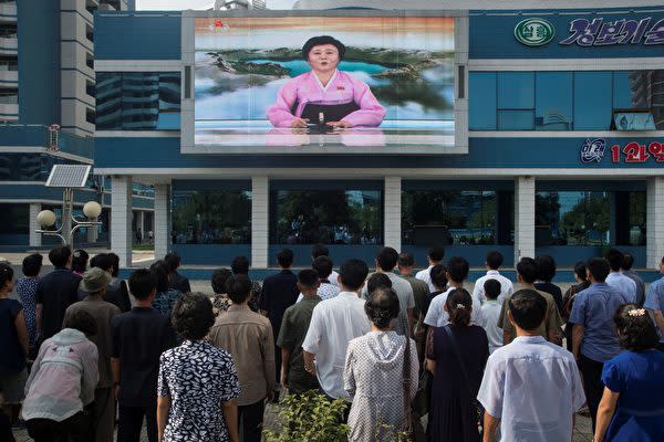 北朝鮮の首都平壌で、スクリーンで放送される国営放送を見つめる北朝鮮の市民(KIM WON-JIN/AFP/Getty Images)