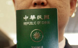 台湾人が台湾に戻れなくなったと中国は主張する。台湾はプロパガンダと批判した。写真は台湾のパスポートを手にする台湾人の男性（PATRICK LIN/AFP/Getty Images）
