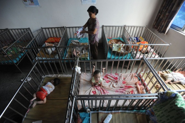 2009年、安徽省のある孤児院で赤ちゃんの世話をする女性（AFP/Getty Images）