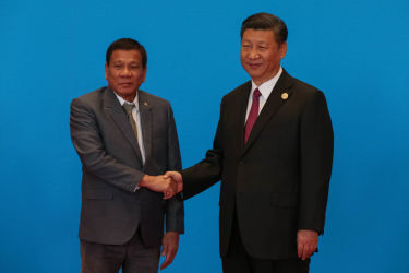 フィリピンのドゥテルテ大統領と中国の習近平主席は、北京で開かれた経済サミット「一帯一路」で握手をかわす(Roman Pilpey-Pool/Getty Images)