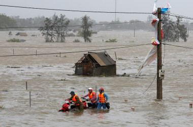 9月15日、台風19号(アジア名:トクスリ)が、ベトナム中部を直撃し、住宅損壊、停電、洪水などの被害をもたらしている。トクスリの勢力はベトナムに上陸する台風としては過去数年で最大。洪水の中バイクを押す人たち。ハティン省で撮影(2017年 ロイター/Nguyen Huy Kham)