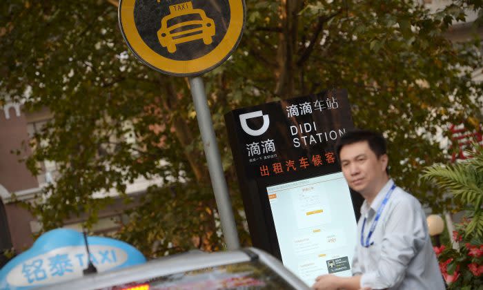 中国上海にある滴滴ステーションで配車を予約した乗客を待っているタクシー運転手。（Chinatopix via AP）