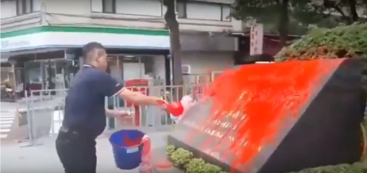 3月7日午後、日本の台湾窓口事務局「日本台湾交流協会」の玄関近くにある石碑に、中華統一促進党の幹部の男が赤いペンキをかける様子。まもなく逮捕された（スクリーンショット）