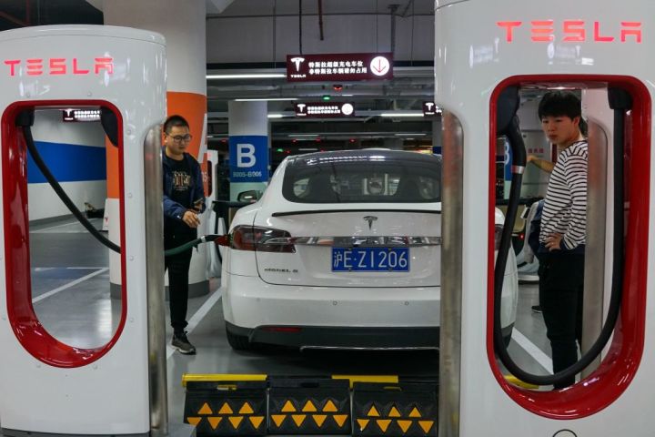 2017年10月、上海にある電気自動車充電器で車両を充電する利用者。 参考写真(CHANDAN KHANNA/AFP/Getty Images)