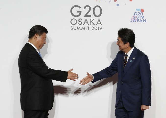 6月28日、大阪G20サミットで握手する安倍晋三首相と習近平国家主席（KIM KYUNG-HOON/AFP/Getty Images）