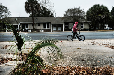 米フロリダ州ペンサコラにある住宅街で、自転車を持って歩いている男性。2016年12月4日撮影。(Spencer Platt/Getty Images)