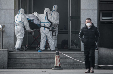 1月18日、武漢市内の病院で新型肺炎の患者を運ぶ医療関係者(STR/AFP via Getty Images)
