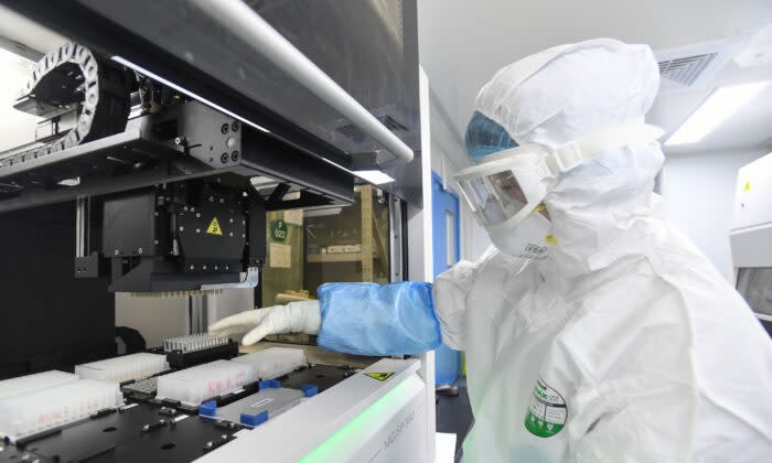 2020年2月6日、中国湖北省武漢市の「火眼」研究所で、検査技師が中共ウイルス（新型コロナウイルス）の検査を受ける人から採取したサンプルを調査している（STR/AFP via Getty Images）