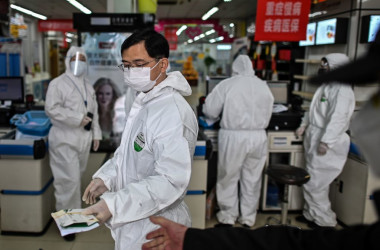 3月30日、武漢市内の薬局で防護服を付けて接客する従業員(GettyImages)