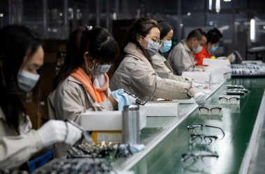 2020年2月28日、中国・温州市にあるアズール眼鏡有限公司で保護マスクを着用しながらメガネフレームを研磨している従業員たち （Noel Celis/AFP via Getty Images）
