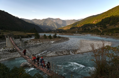 2019年12月6日に撮影された写真は、ブータンのプナカ県にあるプナツァンチュ川にかかる吊り橋の上を歩く観光客の姿(LILLIAN SUWANRUMPHA/AFP via Getty Images)