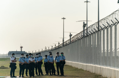 香港の活動家ら12人が収監されている。家族の抗議活動を受けて政府航空関係施設を警備する警察官(GettyImages)