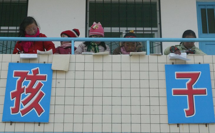 中国陝西省春華県城関郷にある田舎の学校で、放課後に教室のバルコニーで宿題をする子供たち（China Photos/Getty Images）