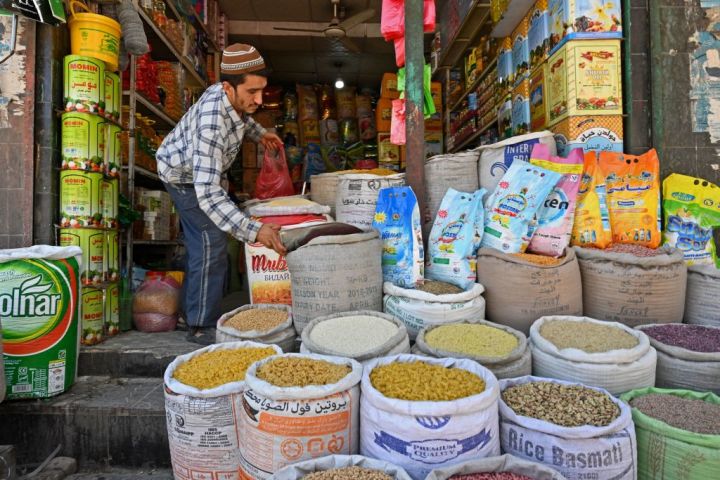 商品の穀物を整理する小売店主。6月18日、カブールにて撮影(Photo by ADEK BERRY/AFP via Getty Images)