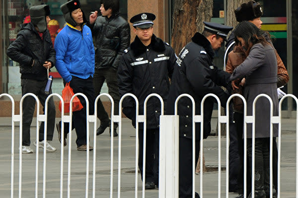 2016年の全国人民代表大会の期間中、天安門広場で通行人の荷物をチェックする警備員（MARK RALSTON/AFP/Getty Images）