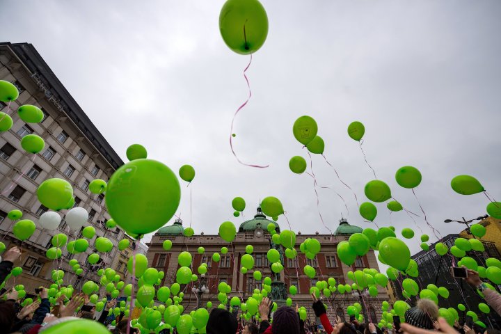 2018年2月15日、ベオグラードで行われた集会で、国際小児がんデーを記念して緑色の風船を持つ人々。参考写真（ANDREJ ISAKOVIC/AFP via Getty Images）