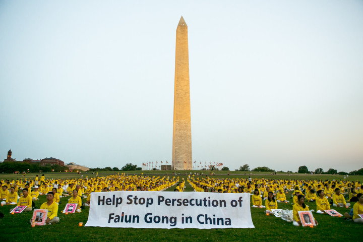法輪功学習者への迫害は今も続いている。写真は2021年7月16日、ワシントンD.C.のワシントン・モニュメントの下で行われたキャンドル・ビジルに参加する法輪功学習者(大紀元)