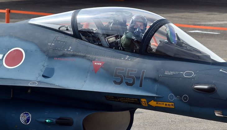 敬礼する航空自衛隊のF-2戦闘機パイロット。2014年10月26日撮影。(Photo credit should read KAZUHIRO NOGI/AFP via Getty Images)