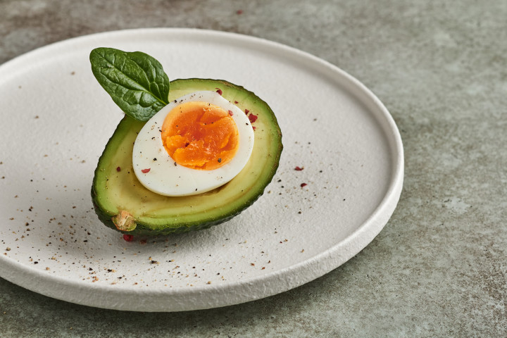 写真半分のアボカドと卵で、美味しくて栄養価の高い朝食が食べられます (Vit57r / PIXTA)