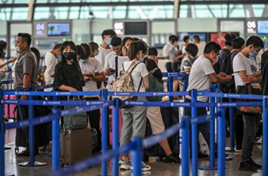 9月の新学期近くになると、米国の渡米規制緩和に伴い、中国の空港の出発ロビーには長蛇の列ができ、航空券の価格も上昇し、10万元を超える「スカイハイ」航空券も登場している。 写真は、2020年6月11日に撮影された、上海浦東空港で列に並ぶ乗客の様子。 (HECTOR RETAMAL/AFP via Getty Images)