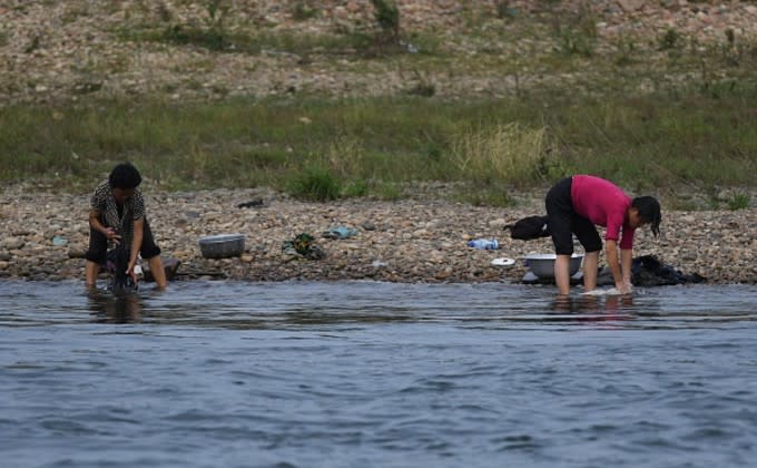 中朝国境の川で衣服を洗う北朝鮮の女性。9月11日撮影(GREG BAKER/AFP/Getty Images)