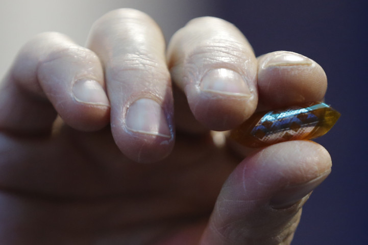 2018年2月27日、バルセロナで開催された世界最大のモバイル見本市で発表されたドイツ・RWTHアーヘン大学のIoTに使われるグラフェンチップを手にする男性（PAU BARRENA/AFP via Getty Images）