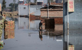 2021年10月11日、中国北部の山西省晋中市で大雨が降った後、浸水地域を進む男性（China OUT/AFP via Getty Images）