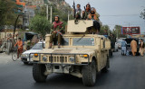 米軍が遺棄した車両に乗るタリバン戦闘員 （Photo by HOSHANG HASHIMI/AFP via Getty Images）