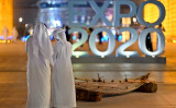 2021年10月26日、アラブ首長国連邦のドバイで開催されている「Expo 2020」のモニュメントとそばにいる人々 （Photo by DIRK WAEM/BELGA MAG/AFP via Getty Images）