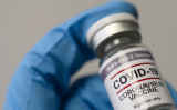 COVID-19のワクチンを手にする医療従事者（Graphs / PIXTA）