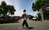 2008年7月17日、中国・北京で、赤い腕章をつけて街をパトロールする高齢女性。2008年北京オリンピックに向けて、当局は退職した住民を「赤い腕章のセーフガード」として組織した。（Guang Niu/Getty Images）