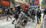 2020年7月1日、香港で行われたデモの際、デモ隊の群衆に向かって道路を走る警察の機動隊（Anthony Kwan/Getty Images）