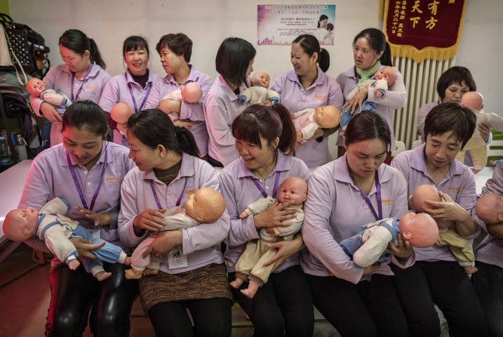 中国・北京の大学で開催された乳母の資格を取るための養成コースで、プラスチック製の赤ちゃんを抱き、トレーニングを受ける女性たち（写真：Kevin Frayer/Getty Images）