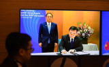 菅首相（当時）立ち会いの下、RCEP協定に署名する梶山経産相（当時）。2020年11月15日撮影 （Photo by NHAC NGUYEN/AFP via Getty Images）