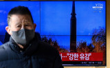 2022年1月11日、韓国ソウルの鉄道駅で、北朝鮮のミサイル実験のファイル映像を使ったニュース放送を流すテレビ画面（Photo by Anthony WALLACE / AFP） （Photo by ANTHONY WALLACE/AFP via Getty Images）