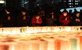 神戸市で阪神淡路大震災の犠牲者に祈りを捧げる人々。1月17日撮影（Photo by STR/JIJI PRESS/AFP via Getty Images）