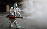 都市封鎖中の西安市で消毒作業を行うスタッフ（STR/AFP via Getty Images）