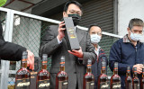 中国に拒否されたリトアニア産のラム酒を手に取る、台湾タバコ酒会社の丁彦哲社長（写真：SAM YEH / AFP） （写真：SAM YEH/AFP via Getty Images）