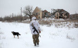 ウクライナ東部・ドネツク地方をパトロールするウクライナ兵士。前方には破壊された建物が見える。 （Photo by ANATOLII STEPANOV/AFP via Getty Images）