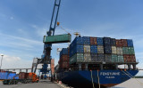 ハイフォン市の港の国際貨物ターミナルで、トラックから貨物船へコンテナを移動する。2019年8月12日撮影（Photo by NHAC NGUYEN/AFP via Getty Images）