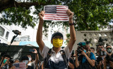 2020年7月4日、香港の米国総領事館の外で、米国独立宣言を祝うために米国旗を掲げる男性（Anthony Kwan/Getty Images）