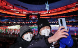 2022年2月4日の北京冬季五輪開会式で、自撮りをするオリンピック作業員たち（Annice Lyn/Getty Images）