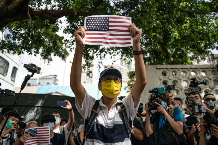 2020年7月4日、香港の米国総領事館の外で、米国独立宣言を祝うために米国旗を掲げる男性（Anthony Kwan/Getty Images）