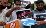 2020年6月30日、インドで動画アプリ「TikTok」を禁止したインド政府を支持して、中国製アプリのロゴが入ったポスターを掲げるシティー・ユース組織のメンバーたち（Noah Seelam/AFP via Getty Images）